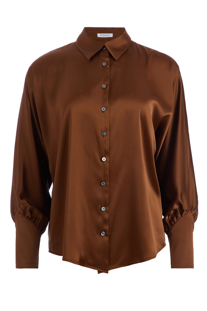 Cinnamon Marna Shirt A silky button down featuring blouson sleeves. Composed of wrinkle resistant vegan silk, this top includes mother of pearl buttons, concealed zippers at wrists, and removable shoulder pads.  