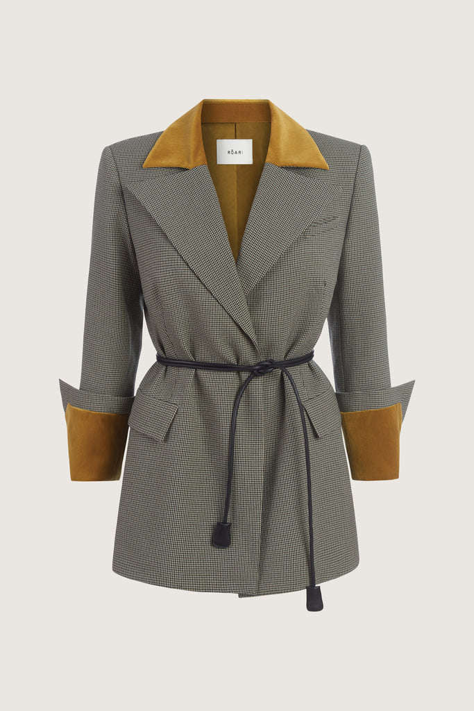 Grey Houndstooth Meredith Blazer This houndstooth blazer is highlighted with contrasting velvet details at the collar and cuffs, providing multiple styling possibilities. It includes a 100% lambskin wrap belt and features a center back vent for added comfort. Molly is 5'9