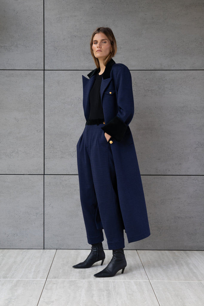 Navy Herringbone Meredith Coat This single breasted Italian wool coat is highlighted with contrasting velvet details at the collar and cuffs, providing multiple styling possibilities. It includes a 100% lambskin wrap belt and features double side vents for enhanced comfort. It is finished with RŌARI's signature gold knot buttons. Fully lined. Styled with The Meredith Trouser | The Meredith Skirt *Please reference our return & exchange policy for Sale & Archived items.