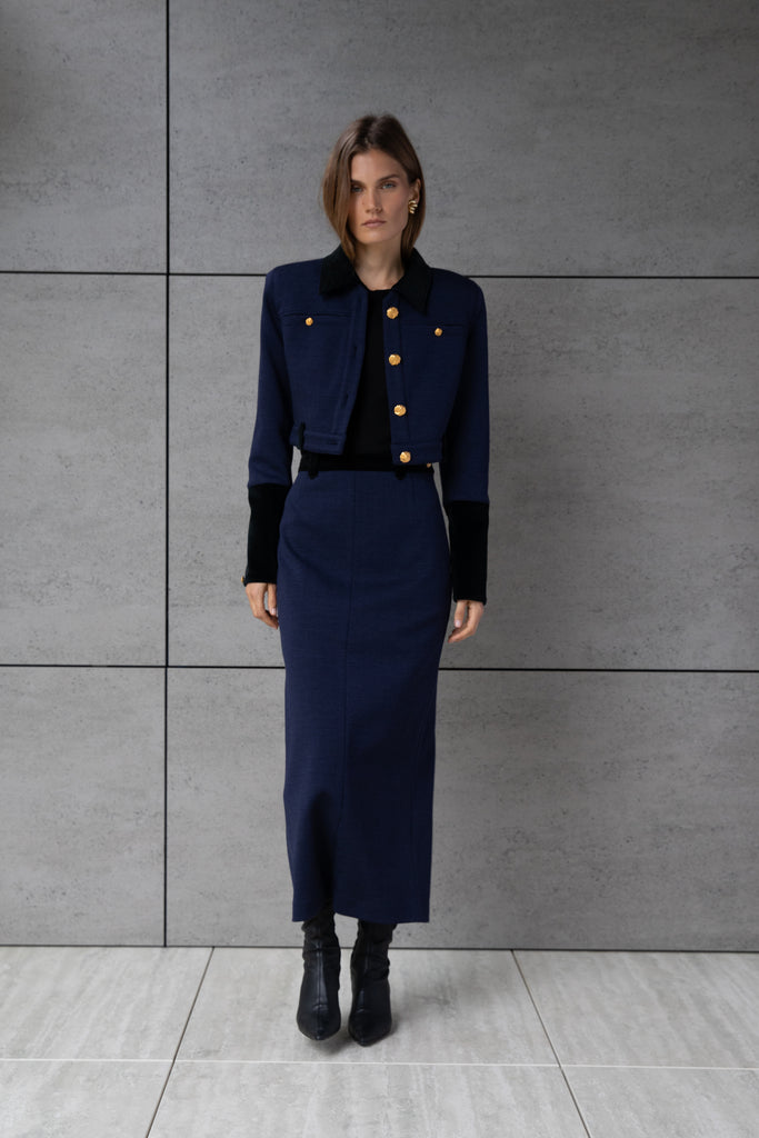 Navy Herringbone Meredith Skirt A fresh take on the classic pencil skirt, this style is crafted with fine Italian virgin wool. Detailed contrasting velvet at waist and finished with ROARI's signature gold knot button at left hip. Fully lined.Styled with The Meredith Jacket | The Meredith CoatAlso available in Black Ostrich *Please reference our return & exchange policy for Sale & Archived items.