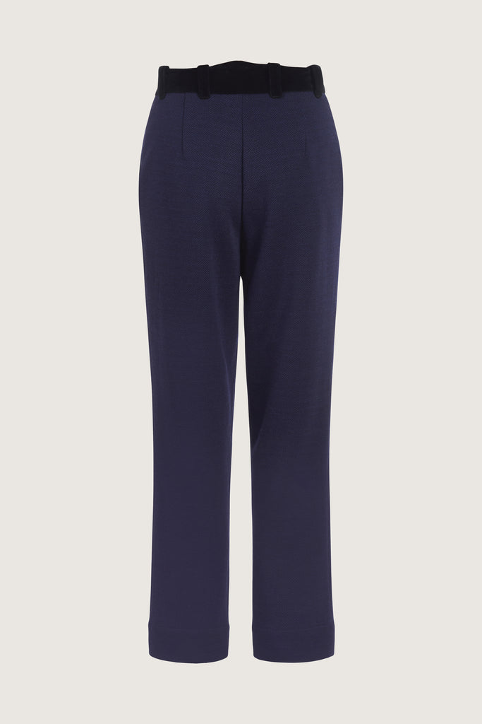 Navy Herringbone Meredith Trouser A fresh take on the classic cigarette leg suit pant, these trousers are crafted with fine Italian virgin wool. Detailed contrasting velvet at waist. Lined. Includes a release at the bottom hem for added length if desired.Styled with The Meredith Jacket | The Meredith CoatAlso available in Grey Houndstooth *Please reference our return & exchange policy for Sale & Archived items.