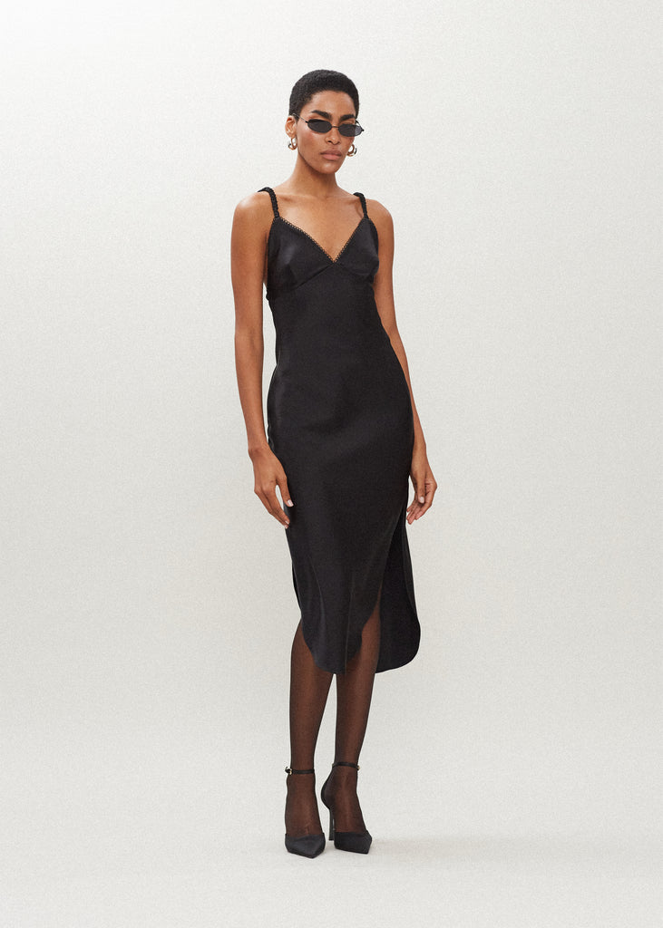 Black Paras Dress The Paras vegan silk midi slip dress features a v-neckline with scalloped trim, bust darts, ruched elastic straps, a low cut open back, and a curved, vented hemline.*Sale merchandise is exchangeable for size/color or store credit. 