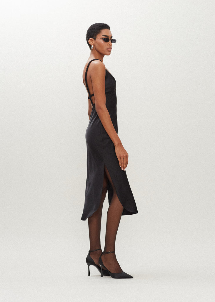 Black Paras Dress The Paras vegan silk midi slip dress features a v-neckline with scalloped trim, bust darts, ruched elastic straps, a low cut open back, and a curved, vented hemline.*Sale merchandise is exchangeable for size/color or store credit. 