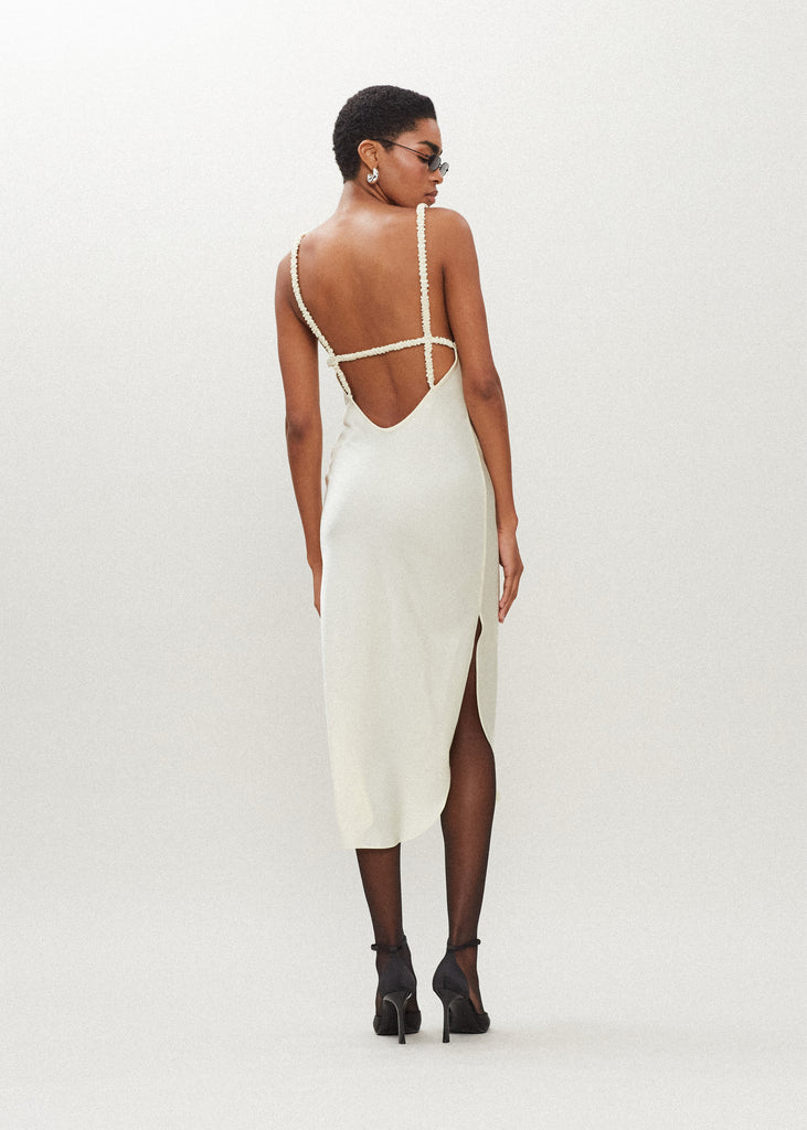 Bone Paras Dress The Paras vegan silk midi slip dress features a v-neckline with scalloped trim, bust darts, ruched elastic straps, a low cut open back, and a curved, vented hemline.SALE MERCHANDISE IS EXCHANGE OR STORE CREDIT ONLY