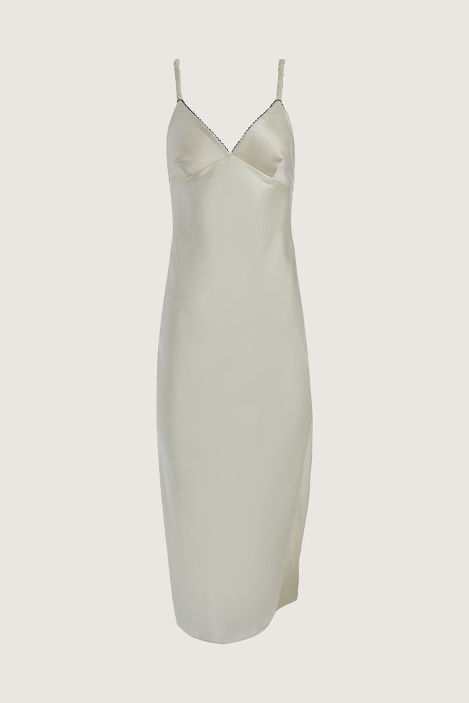 Bone Archive / Paras Dress The Paras vegan silk midi slip dress features a v-neckline with scalloped trim, bust darts, ruched elastic straps, a low cut open back, and a curved, vented hemline.This item is FINAL SALE.