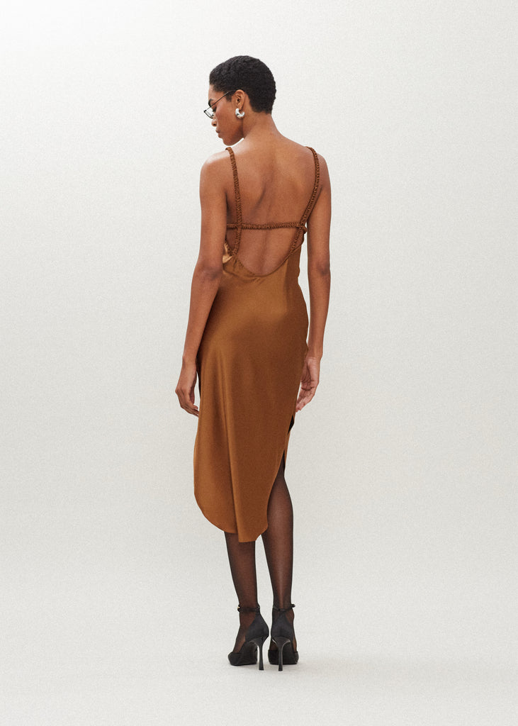 Cinnamon Paras Dress The Paras vegan silk midi slip dress features a v-neckline with scalloped trim, bust darts, ruched elastic straps, a low cut open back, and a curved, vented hemline.SALE MERCHANDISE IS EXCHANGE OR STORE CREDIT ONLY