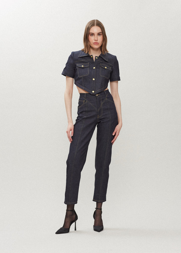 Raw Indigo Quinn Bolero This cropped stretch cotton denim bolero, designed to feel weightless and breathable during all seasons features an asymmetrical curved hem and light shoulder pads for a structured look. Styled with The Sarah Stretch Jean | The Quinn Jean | The Chloe Corset