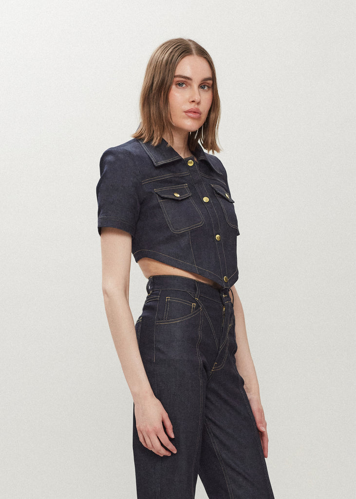 Raw Indigo Quinn Bolero This cropped stretch cotton denim bolero features an asymmetrical curved hem and light shoulder pads for a structured look. 