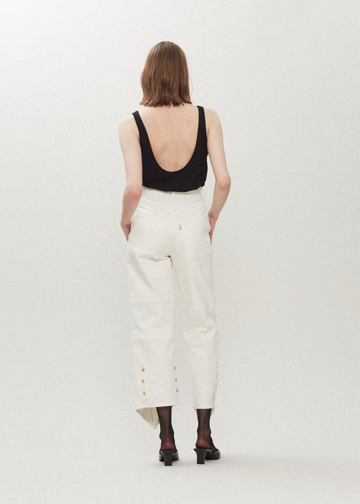 Bone Quinn Jean Lightweight denim with a high-rise relaxed straight leg featuring drop pockets with snap closure, v-shaped front hem, and buttons at back for option to cinch at ankle. Each pair has a branded enameled button.Styled with The Quinn Bolero | The Chloe Corset | The Zoey Tank
