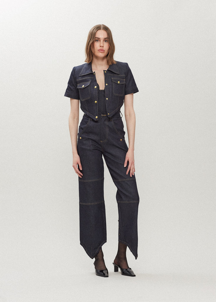 Raw Indigo Quinn Jean High-rise relaxed straight leg jean featuring drop pockets with snap closure, v-shaped front hem, and buttons at back for option to cinch at ankle. Each pair has a branded enameled button. 