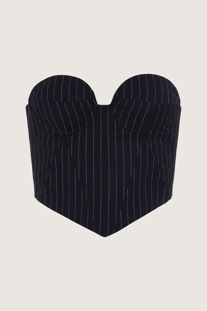 Navy Pinstripe Archive / Ronnie Corset This tailored strapless corset features a fitted suiting bodice with contoured boning, moldable wiring at cups, and shirred back panels to ensure a snug yet flexible fit. Slightly cropped with a v-front silhouette.Style with The Ronnie Blazer | The Ronnie Trouser | The Ronnie SkirtThis item is FINAL SALE.