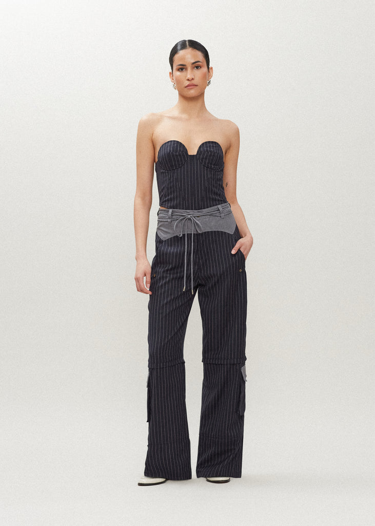 Navy Pinstripe Ronnie Trouser High-rise lightweight tailored trouser featuring contrasting waistband with self-fabric tie tunneled through two rows of belt loops. Featuring a relaxed leg fit with cargo style pockets and horn buttons.
