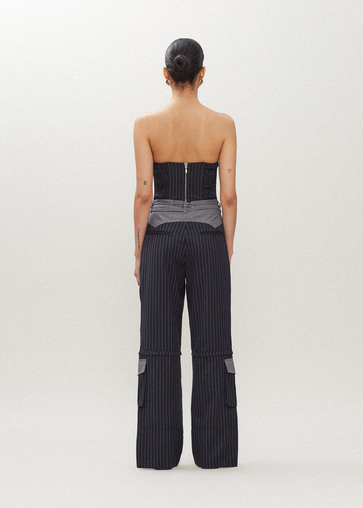 Navy Pinstripe Ronnie Trouser High-rise lightweight tailored trouser featuring contrasting waistband with self-fabric tie tunneled through two rows of belt loops. Featuring a relaxed leg fit with cargo style pockets and horn buttons.