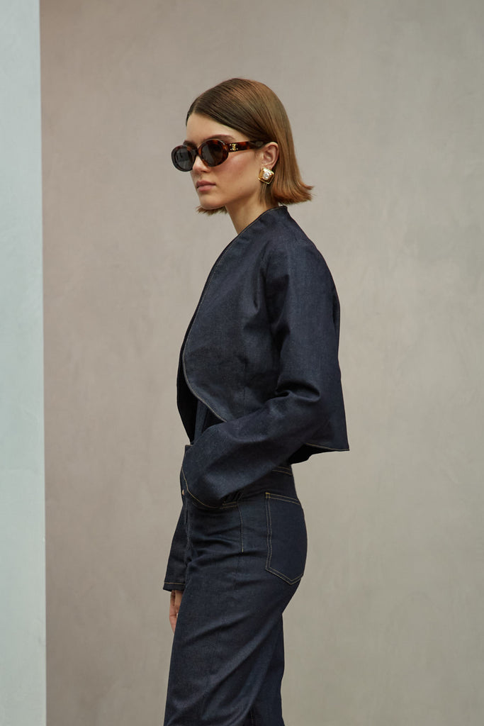 Raw Indigo Sasha Stretch Bolero This bolero jacket is cut from a lightweight cotton denim elastane blend, designed to feel weightless and breathable during all seasons . It features an open front lapel and cropped length.Styled with The Sarah Stretch Jean | The Chloe Corset