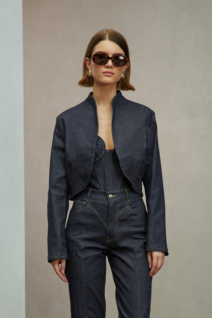 Raw Indigo Sasha Stretch Bolero This bolero jacket is cut from a lightweight cotton denim elastane blend, designed to feel weightless and breathable during all seasons . It features an open front lapel and cropped length.Styled with The Sarah Stretch Jean | The Chloe Corset