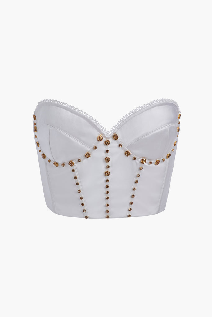 White PETRA CORSET Boasting a vintage-inspired silhouette, the Petra Corset is crafted with hand-applied gold-and-crystal flower hardware, boning, and underwire. It features lightly lined cups for superior support and a low back with an adjustable hook-and-eye closure, ending at the natural waist. Handmade in India.*All sale merchandise is exchangeable for size only.