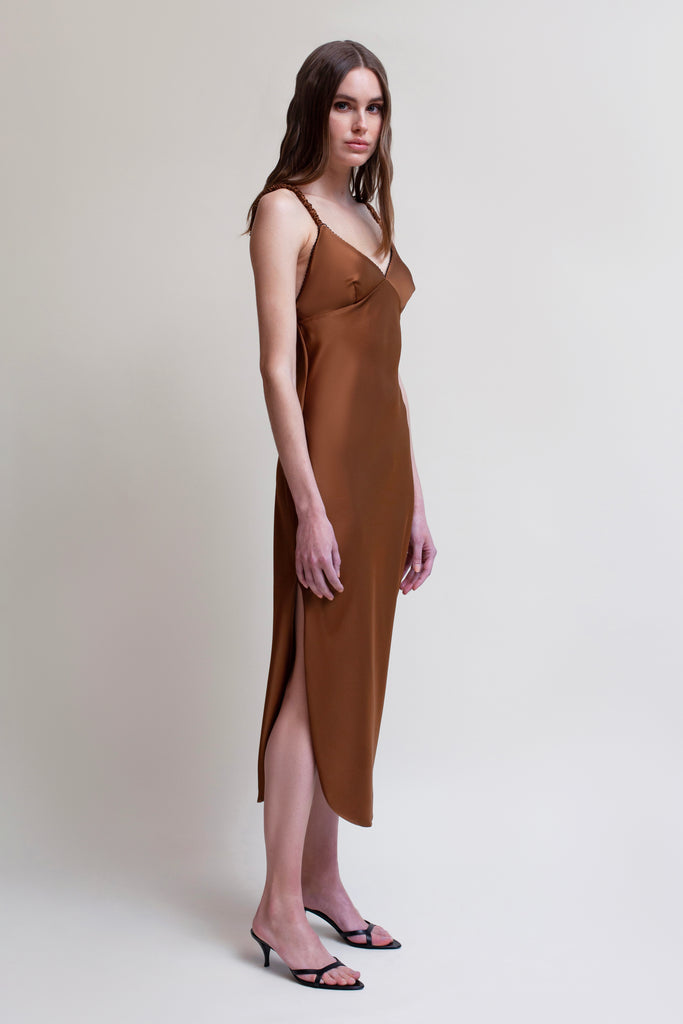Cinnamon PARAS DRESS The Paras vegan silk midi slip dress features a v-neckline with scalloped trim, bust darts, ruched elastic straps, a low cut open back, and a curved, vented hemline.*All sale merchandise is exchangeable for size only.