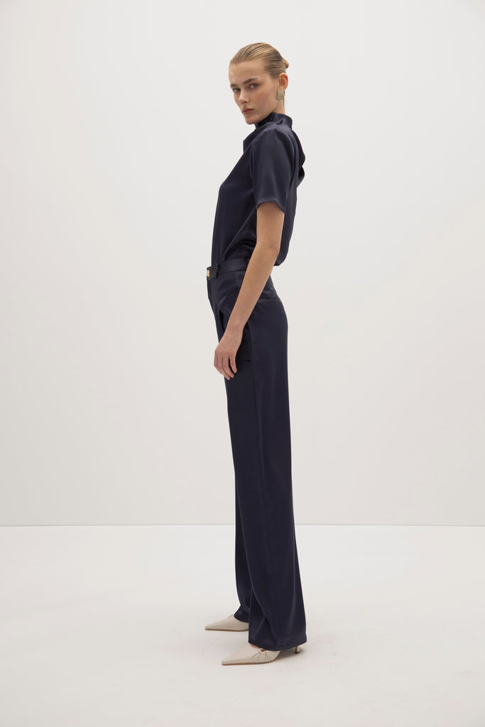 Navy Vivien Top -Cowl neckline with stacked collar-Self-loop and gold knot button at back neck-Removable shoulder pads with interior pockets-French seams for clean finish-1/4” baby hem on sleeves and body-Fluid drape with tailored structure Cara is 5'10